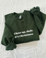 Elevate your holiday spirit with our "Cheer Up, Dude" Sweatshirt. This cozy essential features a fuzzy soft interior that's perfect for staying warm and comfortable during the festive season. With unisex sizing and ribbed knit details, it's a versatile and stylish addition to your winter wardrobe. Spread cheer and laughter with a touch of holiday humor – 'tis the season to be jolly, after all. Get ready to embrace the joy and stay toasty in style with this must-have sweatshirt.