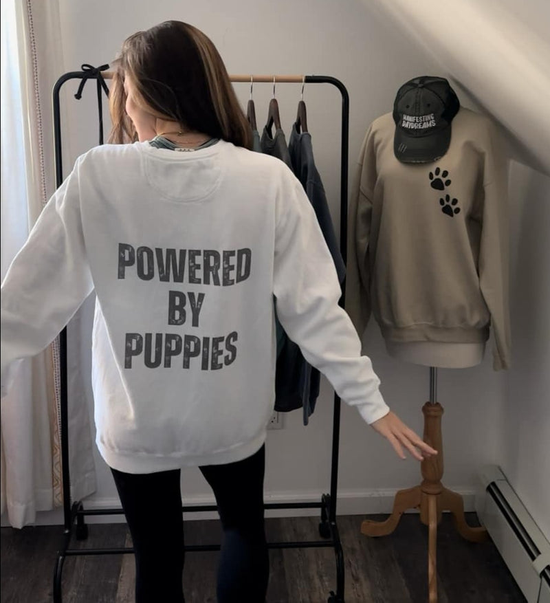 Can you feel the puppy love? Get cozy in our "Powered By Puppies" sweatshirt because let's face it, puppies make the world a better place! 🐾✨ Unleash the cuteness, spread the joy, and stay snug with a touch of furry magic!🐶