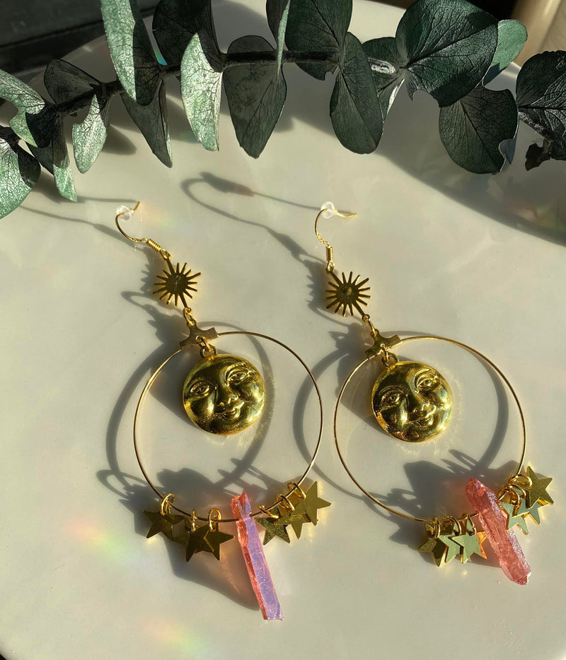 Step into a realm of ethereal beauty with our Pink Aura Quartz Moon Hanging Earrings. These exquisite earrings feature delicate moons and shimmering Pink Aura Quartz, a stone known for its enchanting and soothing energy. 