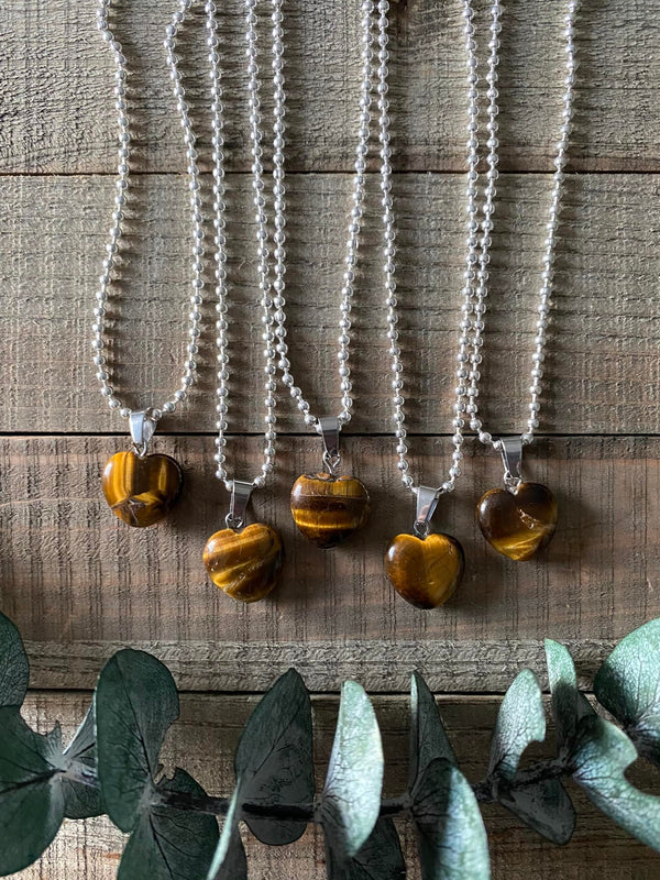 Elevate your style and harness the empowering energy of our Tiger's Eye Crystal Heart Necklace. Tiger's Eye, known as the 'Stone of Courage,' empowers you to overcome challenges, embrace your personal power, and manifest your dreams. Its golden hues reflect a fierce and grounding energy that enhances clarity of thought and decision-making.