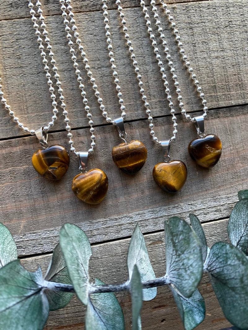 Elevate your style and harness the empowering energy of our Tiger's Eye Crystal Heart Necklace. Tiger's Eye, known as the 'Stone of Courage,' empowers you to overcome challenges, embrace your personal power, and manifest your dreams. Its golden hues reflect a fierce and grounding energy that enhances clarity of thought and decision-making.
