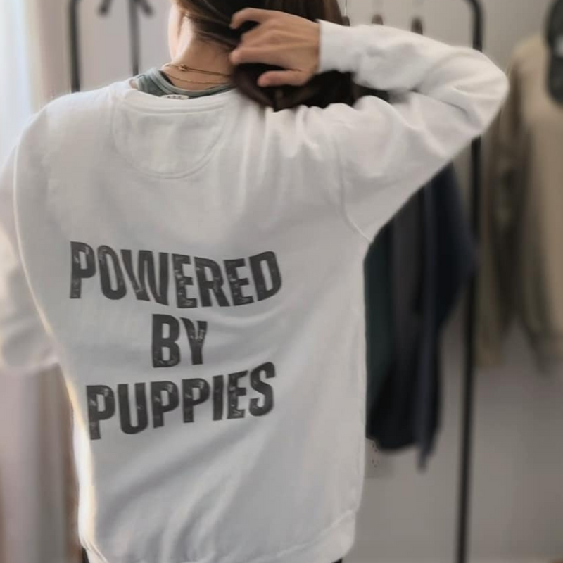 Can you feel the puppy love? Get cozy in our "Powered By Puppies" sweatshirt because let's face it, puppies make the world a better place! 🐾✨ Unleash the cuteness, spread the joy, and stay snug with a touch of furry magic!🐶