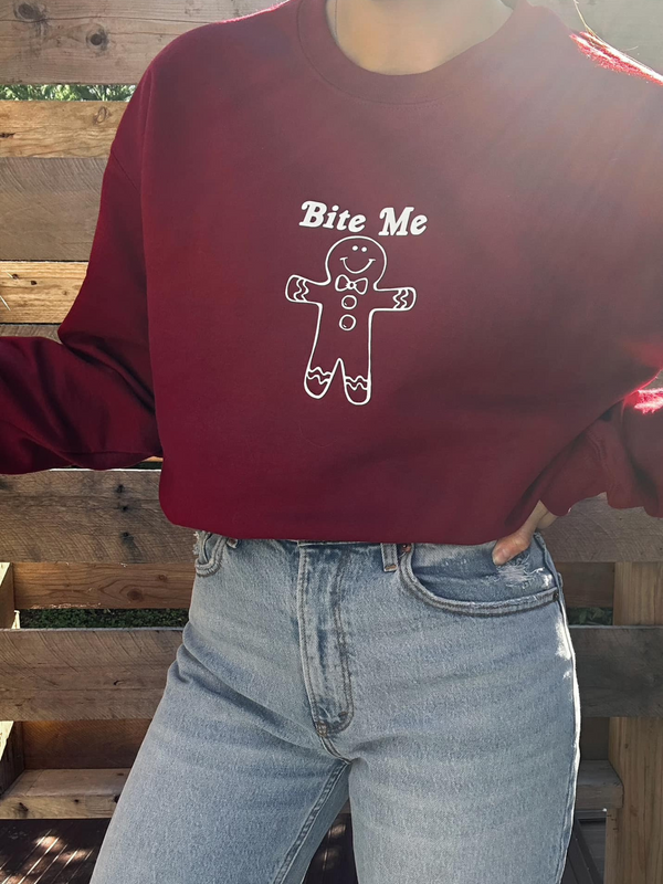 Introducing our "Bite Me" Sweatshirt, the sweet and sassy addition your wardrobe needs this season. Designed for comfort and style, this sweatshirt showcases a cute gingerbread character that's sure to bring a smile to your face. Made with soft, high-quality fabric, it's perfect for keeping warm and cozy during chilly days. Whether you're spreading a bit of holiday humor or simply embracing your unique sense of style, this sweatshirt is a delightful choice. 